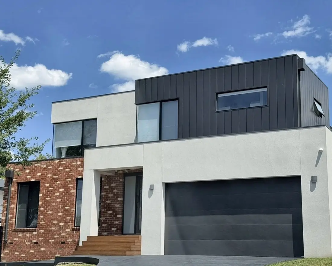 Modern double-storey home with render, black cladding and recycled brick