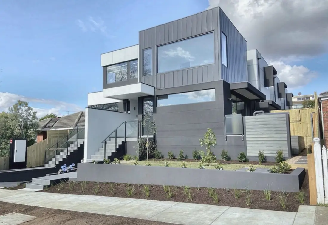 Modern townhouse development with metal cladding and landscaped frontage